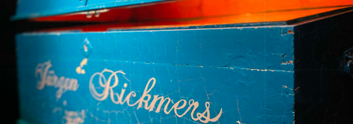 Seemannskiste aus Holz in blau und mit weißer, schnörkeliger Schrift: Jürgen Rickmers